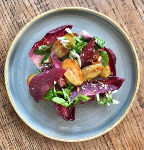 Jersey Royals with red wine poached pear, chicory and watercress salad, Cornish blue & candied walnuts